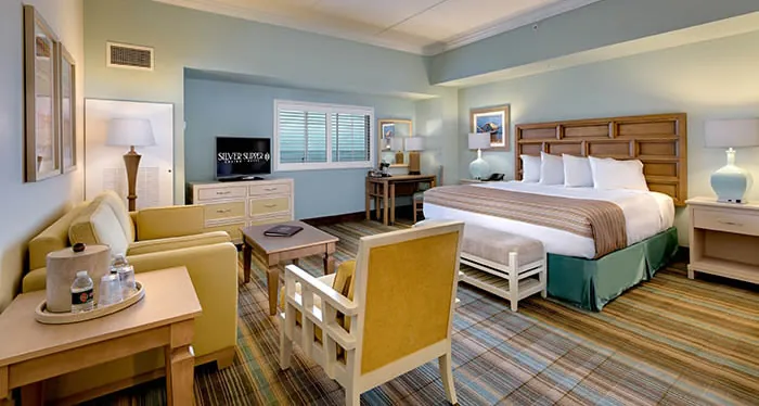 Silver Slipper junior suite with king bed, sitting area, desk, and Gulf Coast décor